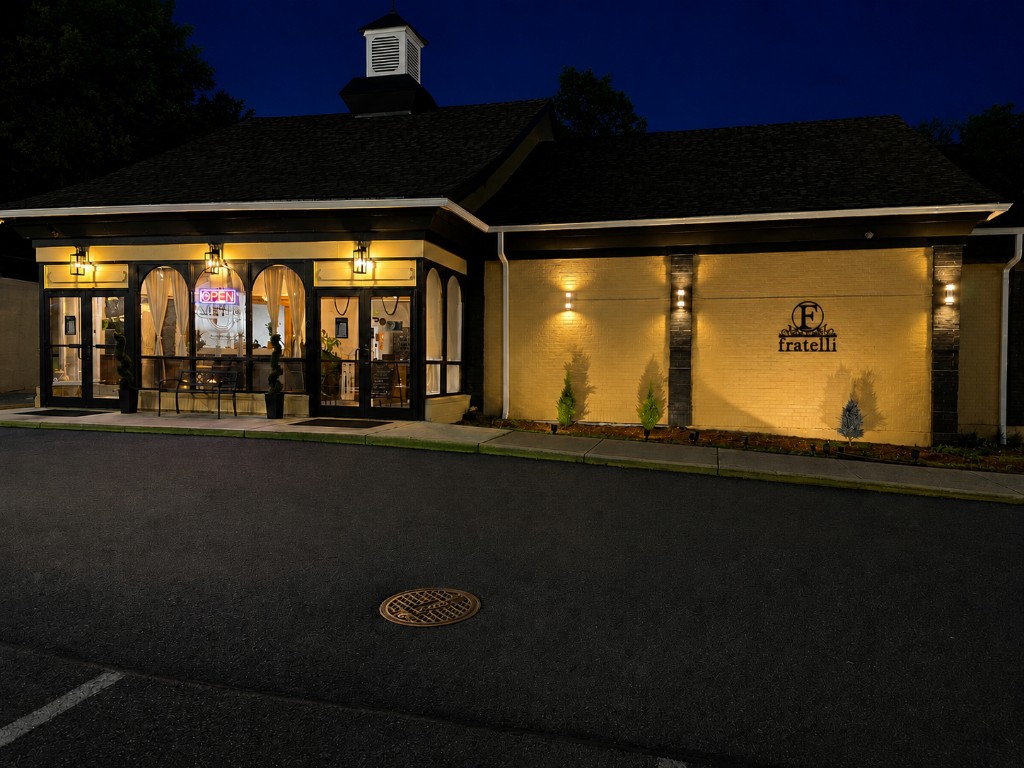 Fratelli Restaurant exterior at night — Alexandria, Virginia Fratelli restaurant at night in Alexandria, VA — inviting entrance, warm lighting, and family-owned Italian fine dining
